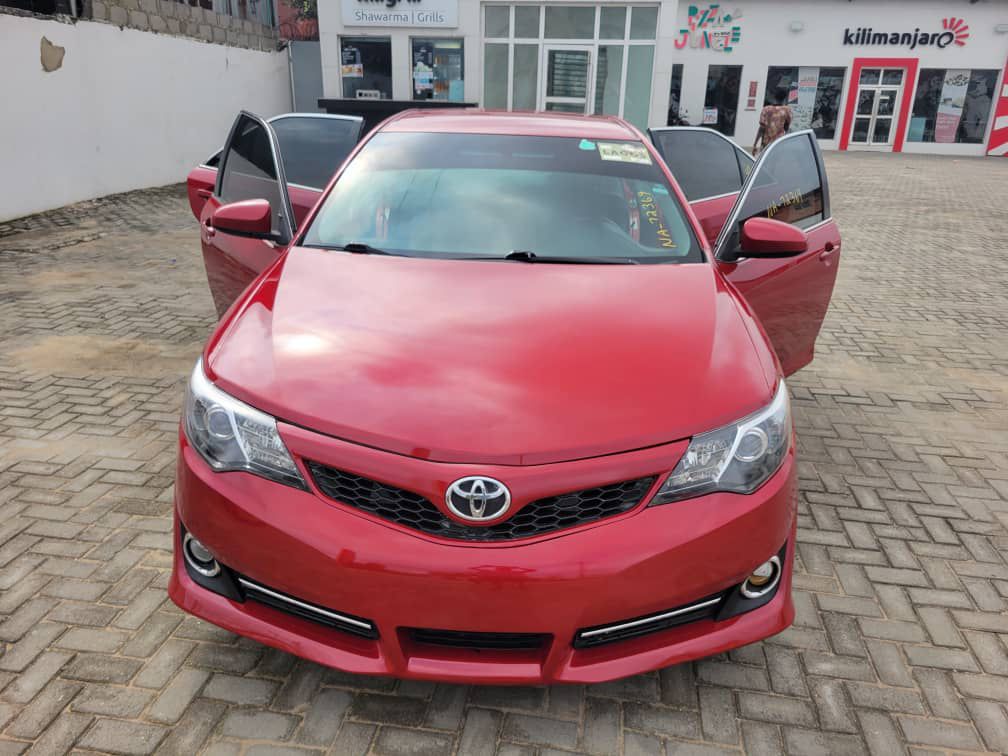 Silver 2019 Nissan X-Trail SUV parked near a busy market in Port Harcourt with people and stalls around